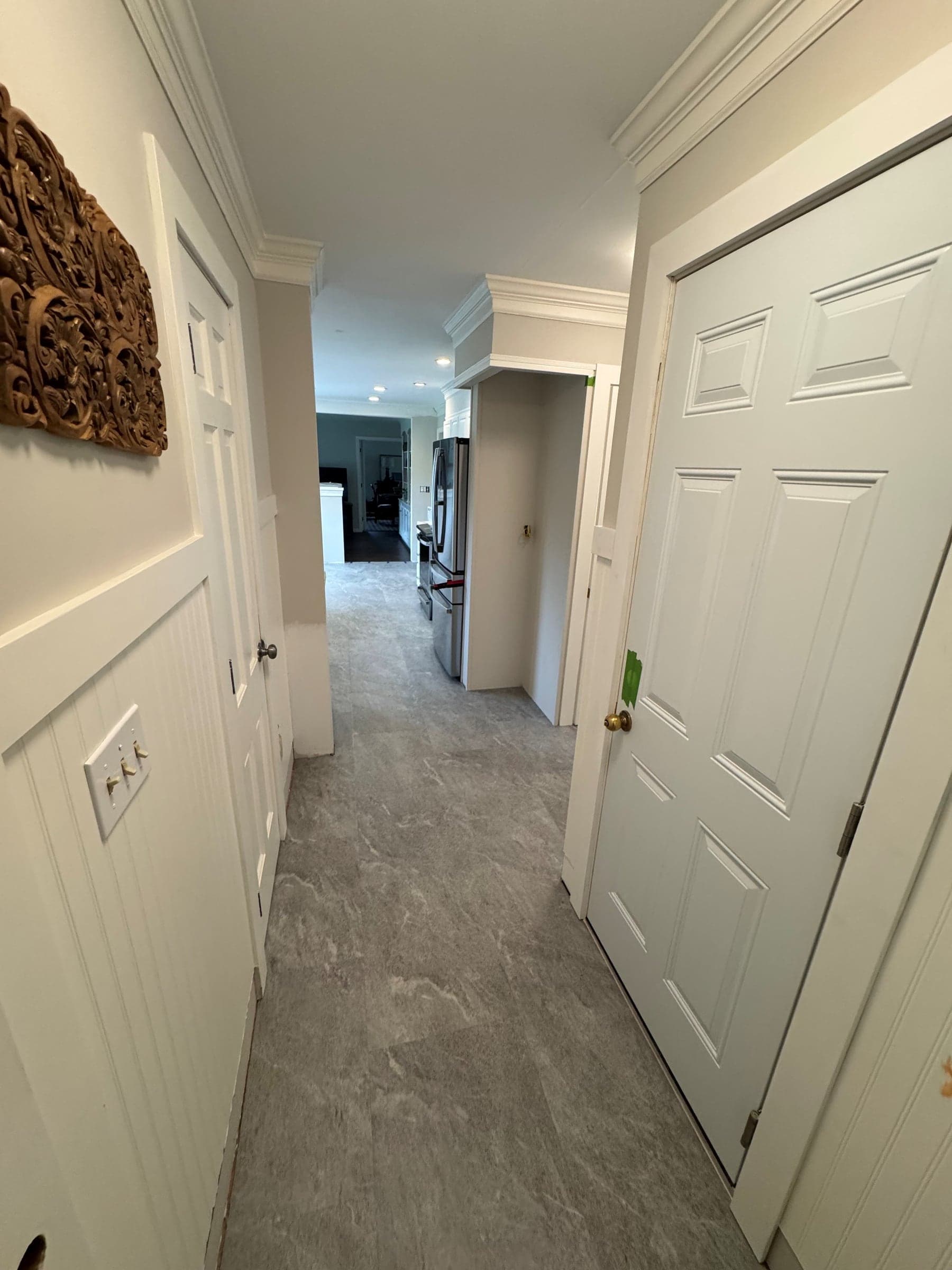 Stone-look Karndean Sterling Quartzite flooring in a white-trimmed Kensington hallway leading toward the kitchen