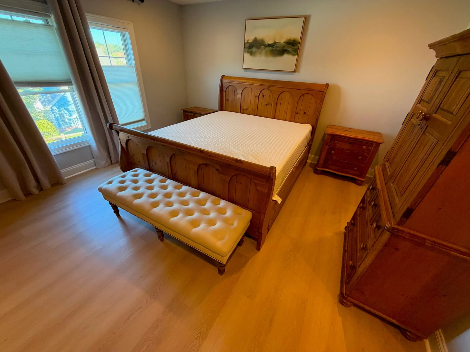 Completed Shaw Endura Plus White Sand luxury vinyl plank floor in a Newington bedroom with wood furniture