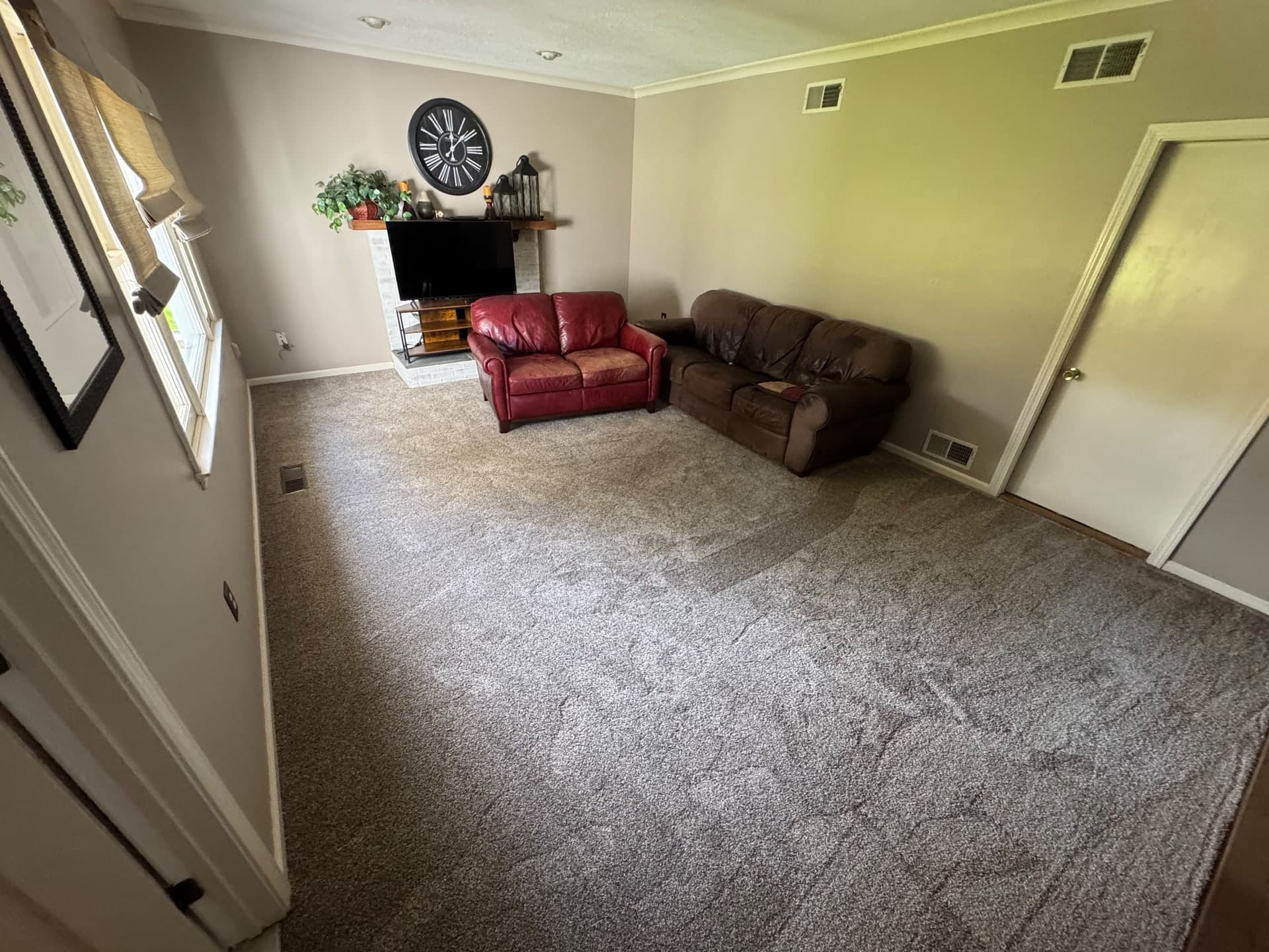 Finished Honeycomb carpet in a Rocky Hill family room with red and brown sofas and a fireplace