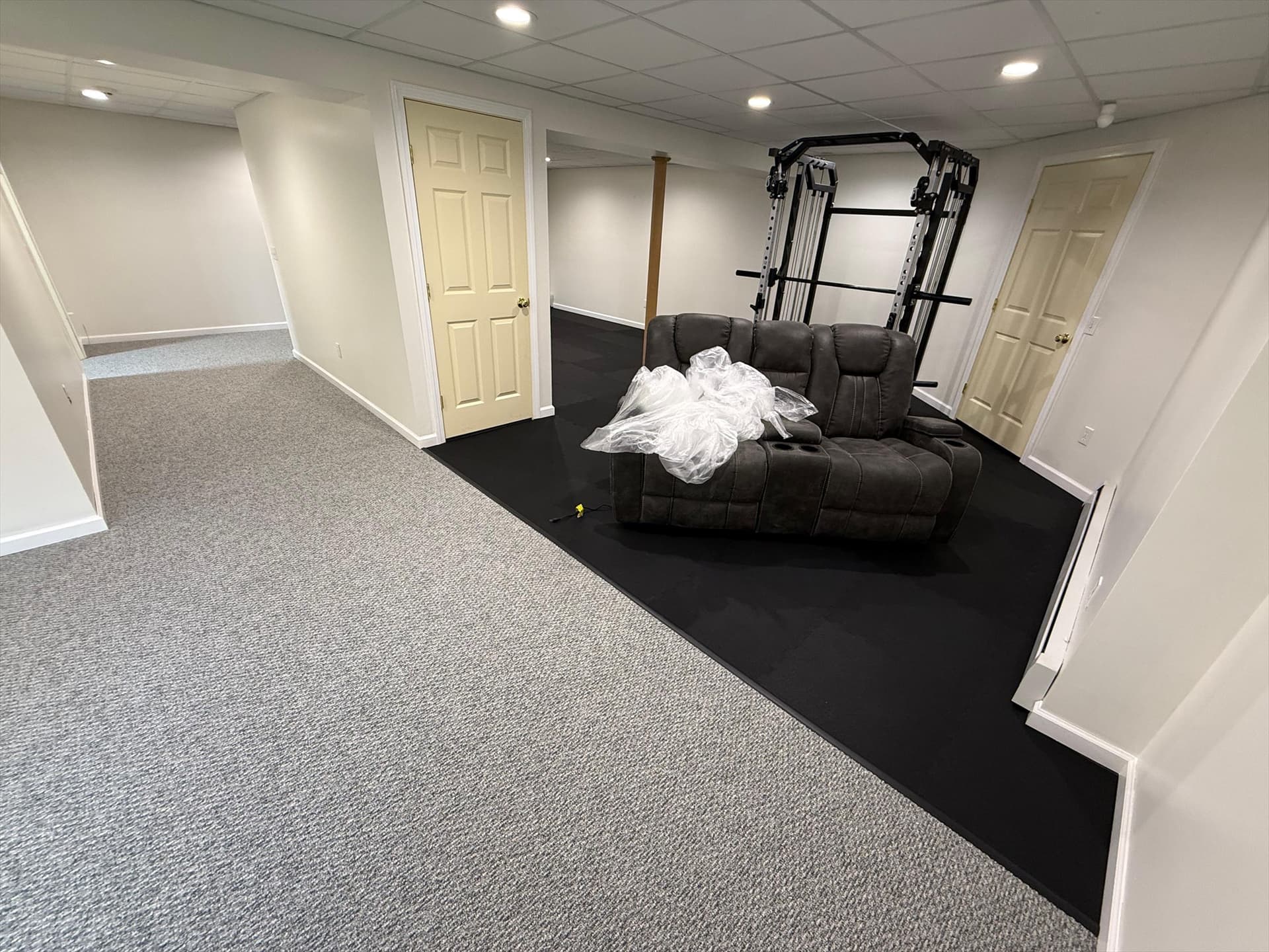 Madoc Coracle carpet beside Advanced Edge AE400 black rubber gym flooring in a Colchester basement