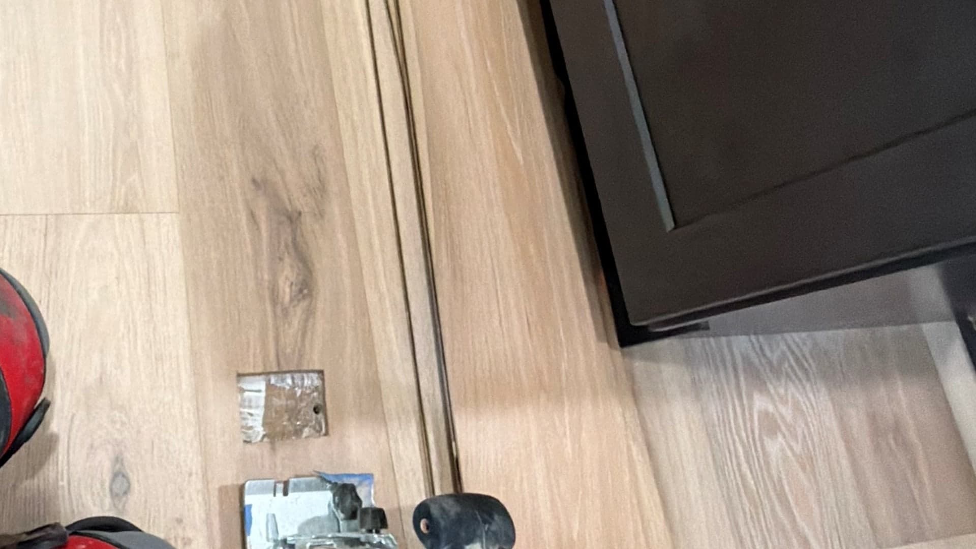 Engineered hardwood board replacement in progress beside a Colchester kitchen island after a floor outlet was removed