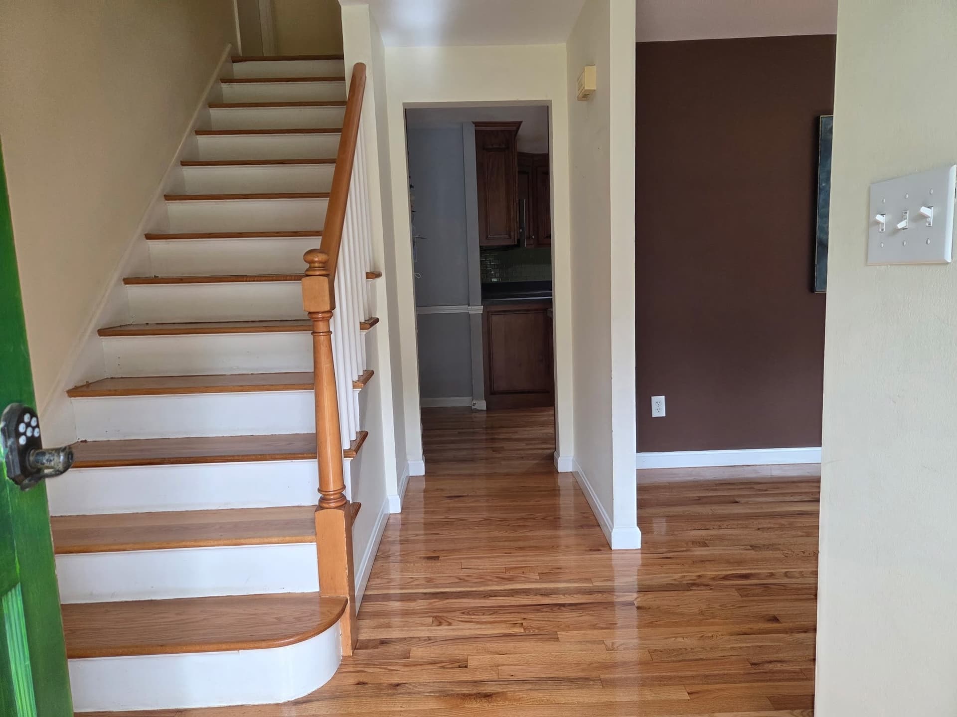 Stained and refinished hardwood in an Ellington entry with stairs and views into the kitchen and living area