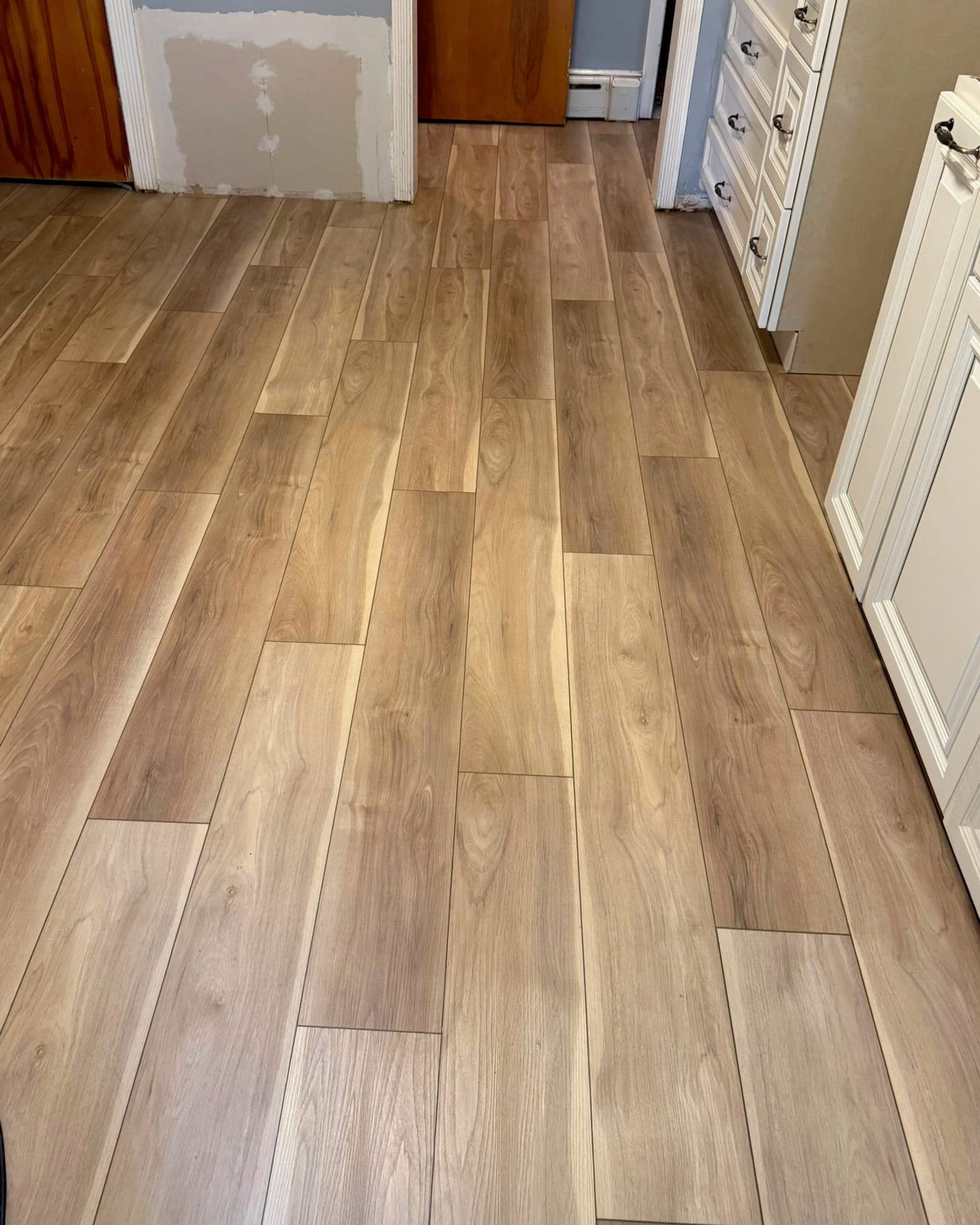 Warm wood-look rigid-core luxury vinyl flooring in a Farmington kitchen