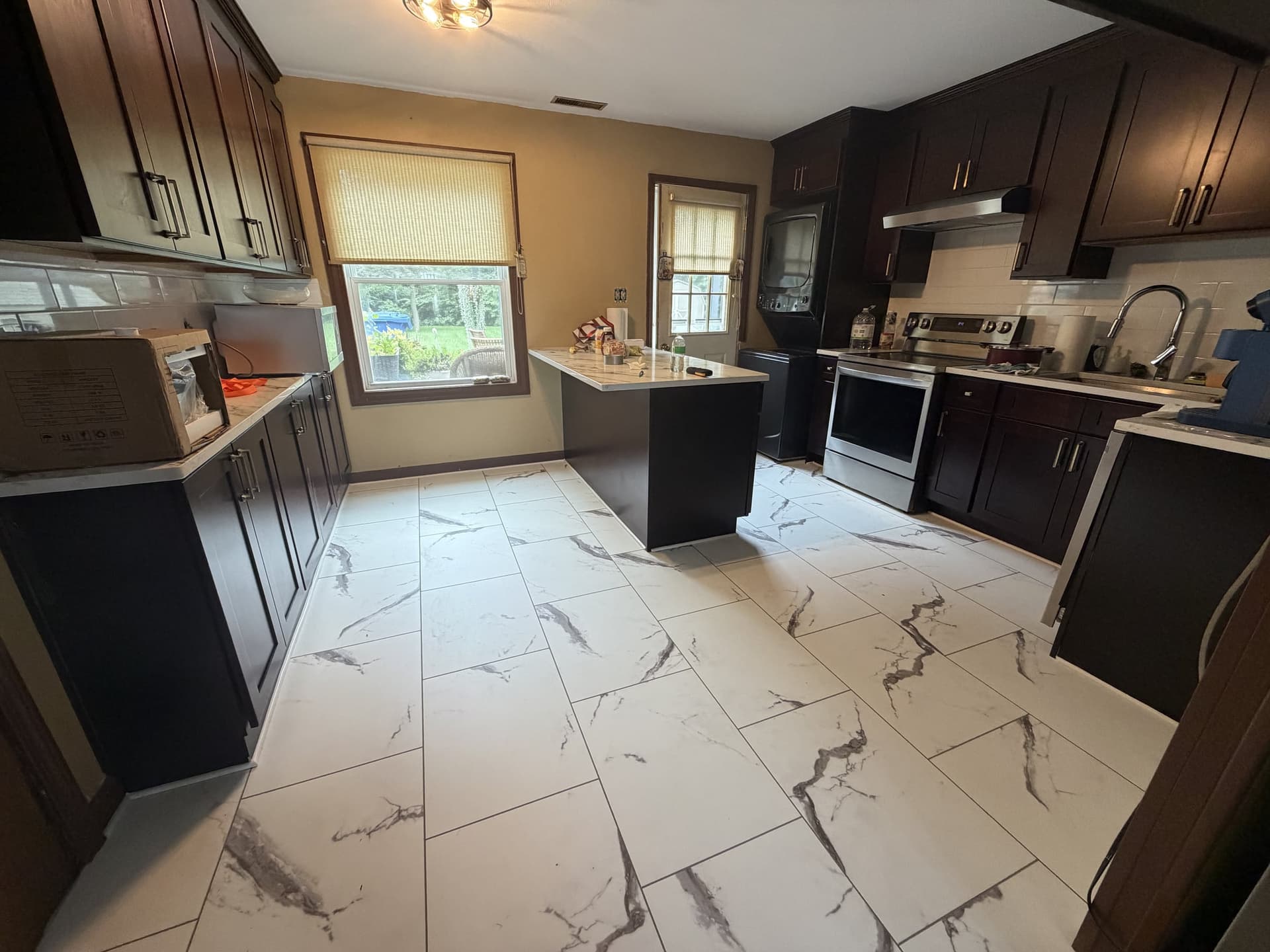 White marble-look Karndean Korlok Select Brunella Marble rigid-core luxury vinyl tile installed in a Meriden kitchen with dark cabinets