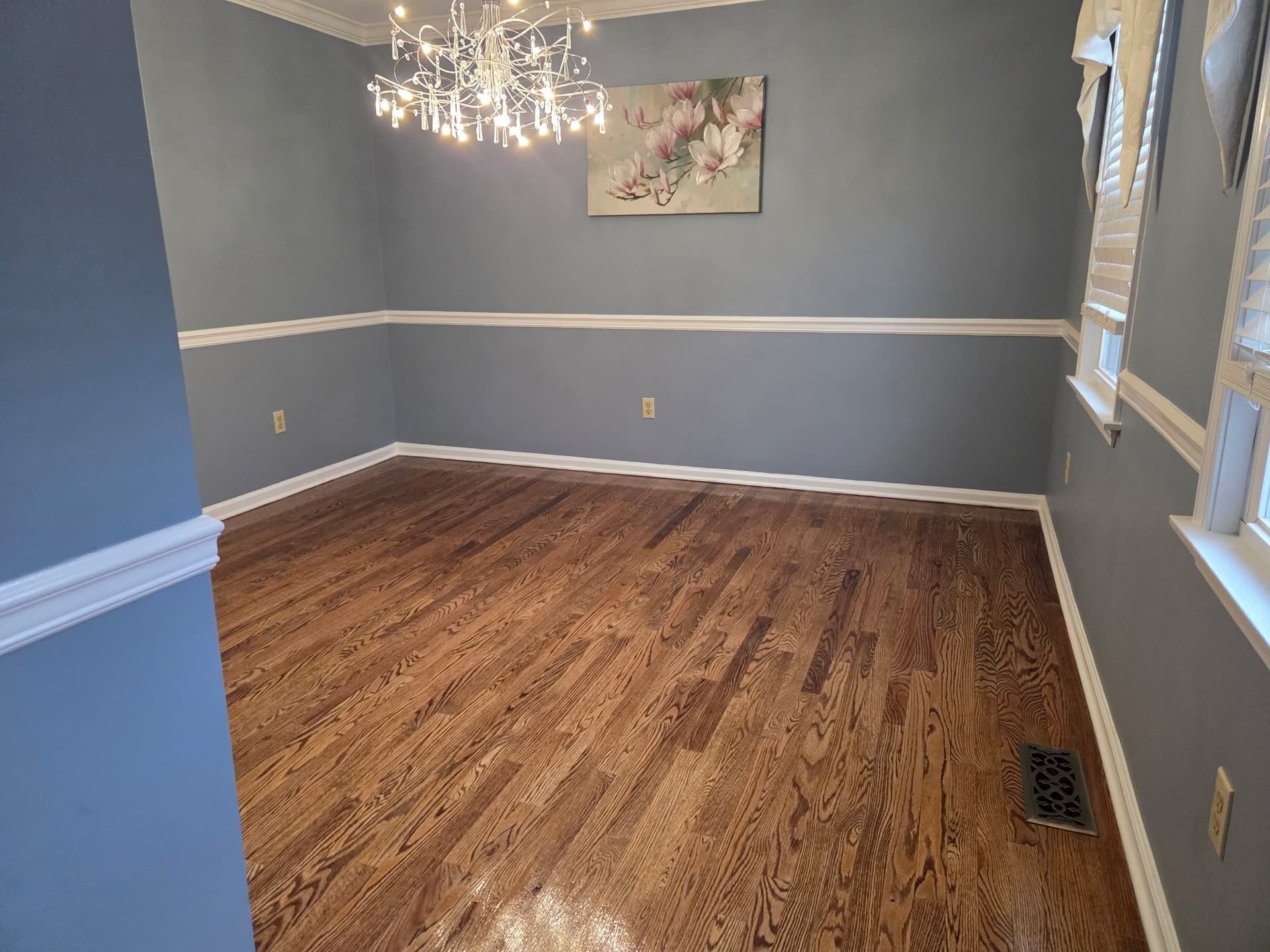Sanded, stained, and finished hardwood flooring in a Monroe dining room with blue walls and white trim