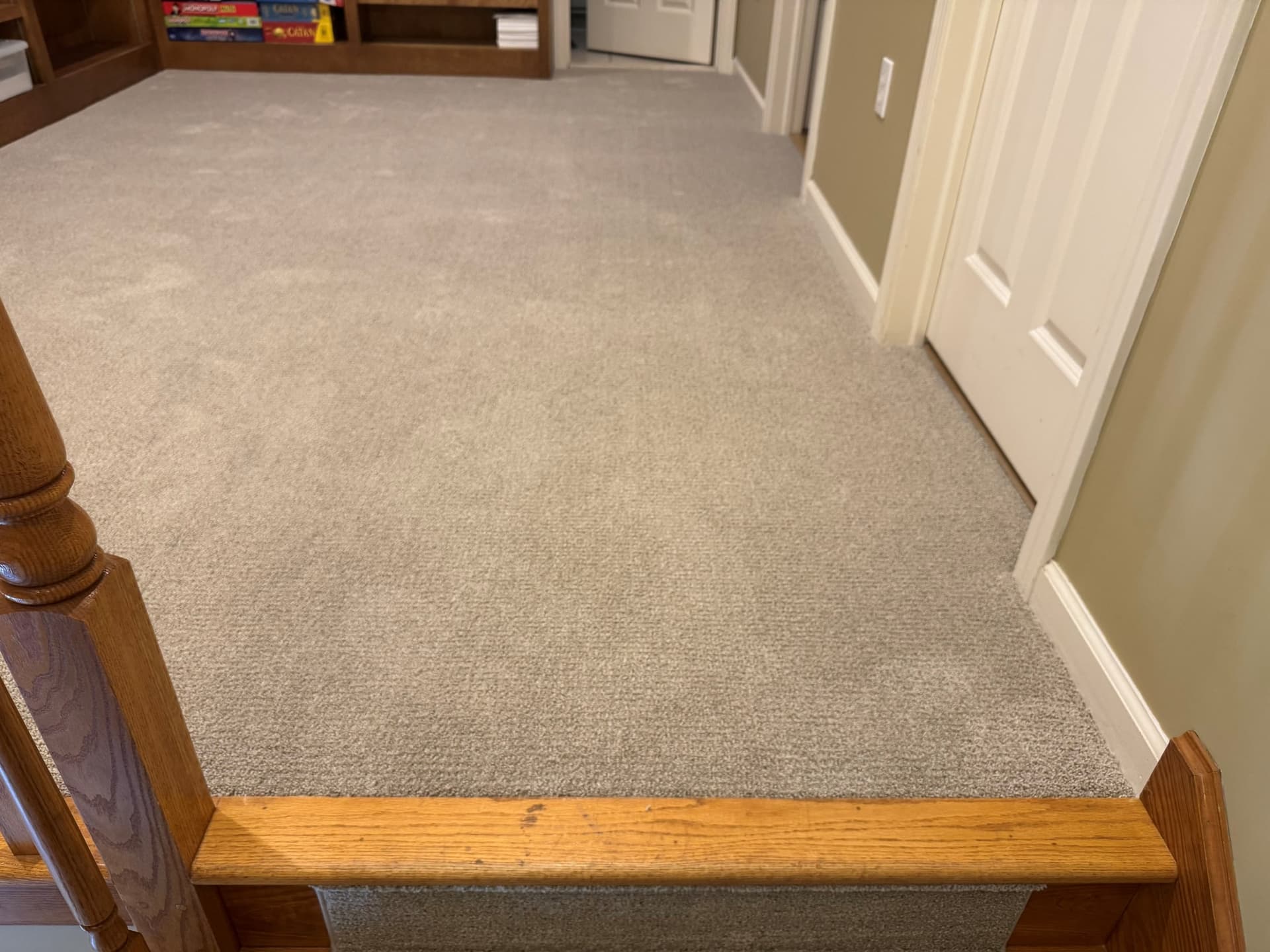 Fieldcrest carpet in the upstairs hallway beside the wooden top stair nosing and railing