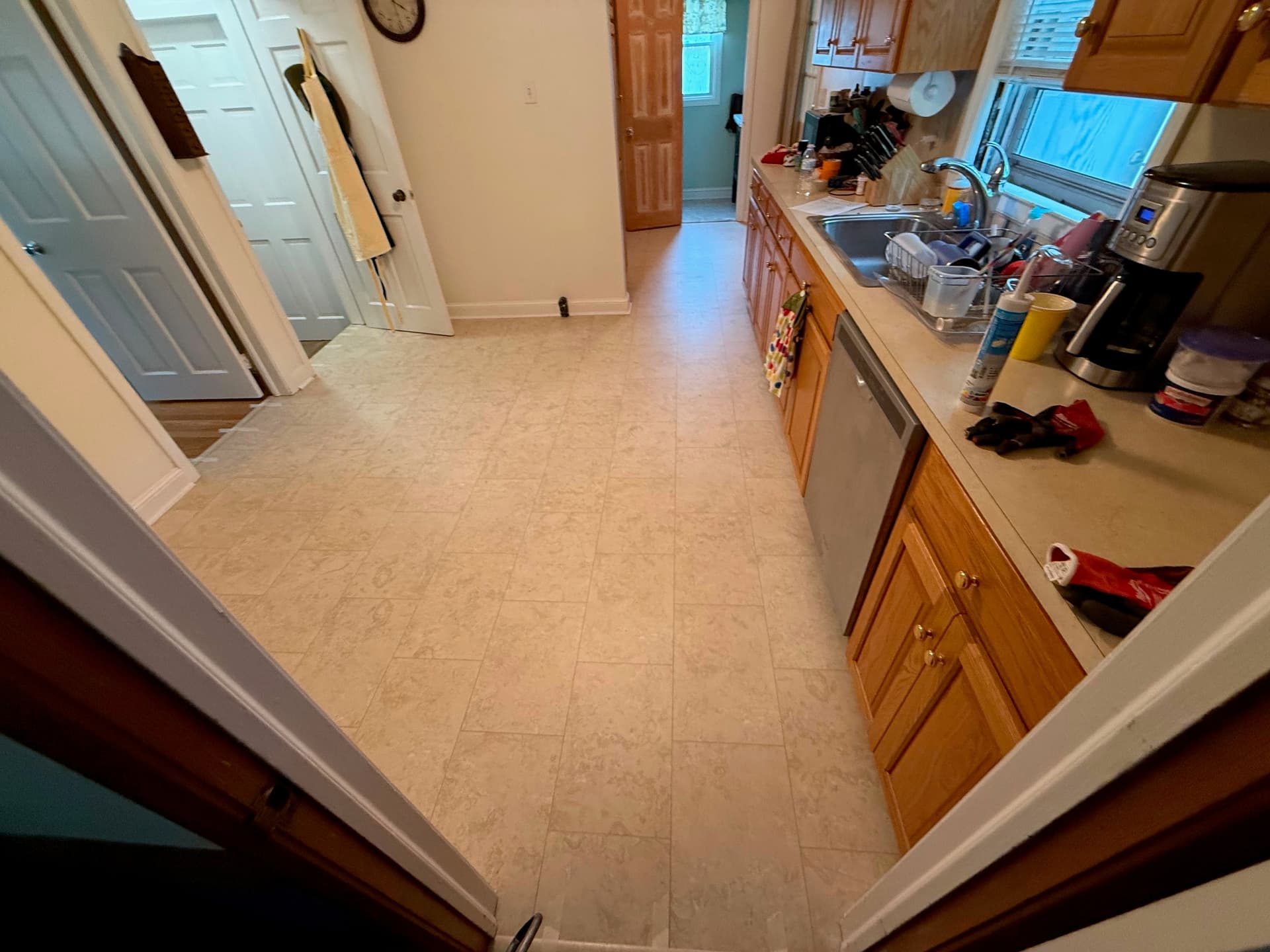 Completed Karndean Knight Tile Natural Limestone gluedown LVT with Cream design strips in a West Hartford kitchen
