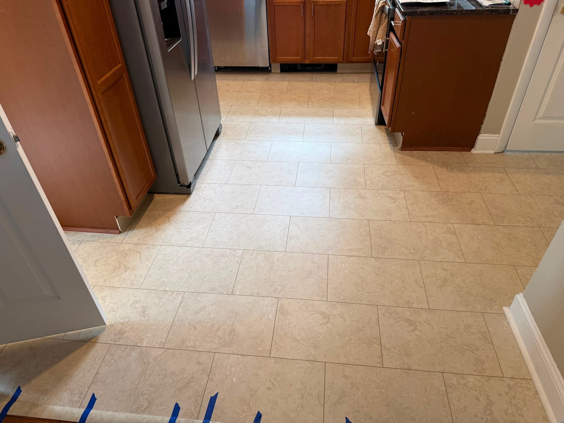 Karndean Natural Limestone LVT installed across a West Hartford kitchen with wood cabinets and stainless steel appliances