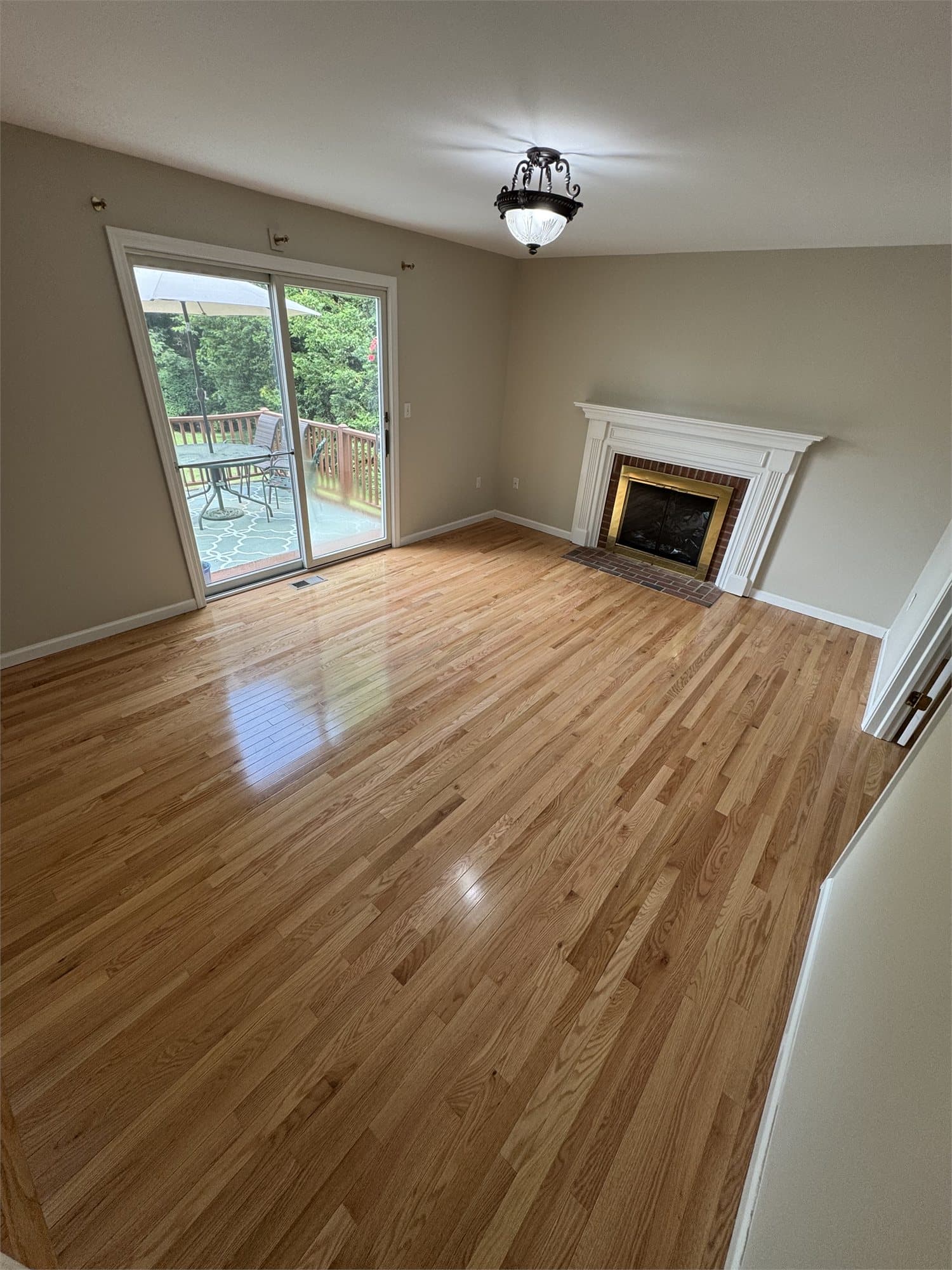 Somerset High Gloss Collection Natural Red Oak solid hardwood installed beside a fireplace in a West Hartford family room